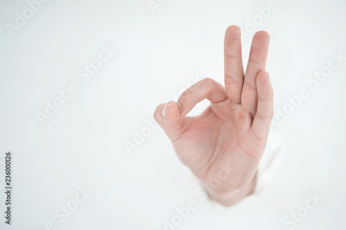 man's hand breaking through the paper wall and pointing at you