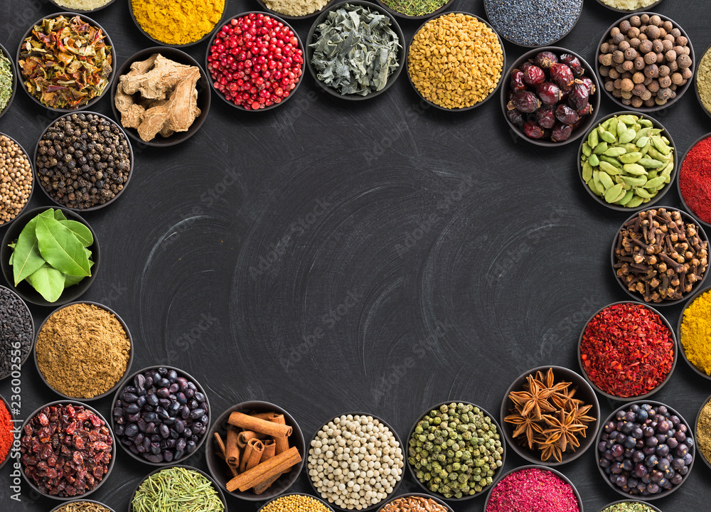 different condiments lie around. Indian spices and herbs on black table.  Seasoning with empty space for text Stock Photo | Adobe Stock