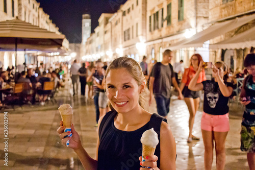 Frau hält leckeres Eis in der Händen in der belebten Altstadt von Dubrovnik, Kroatien