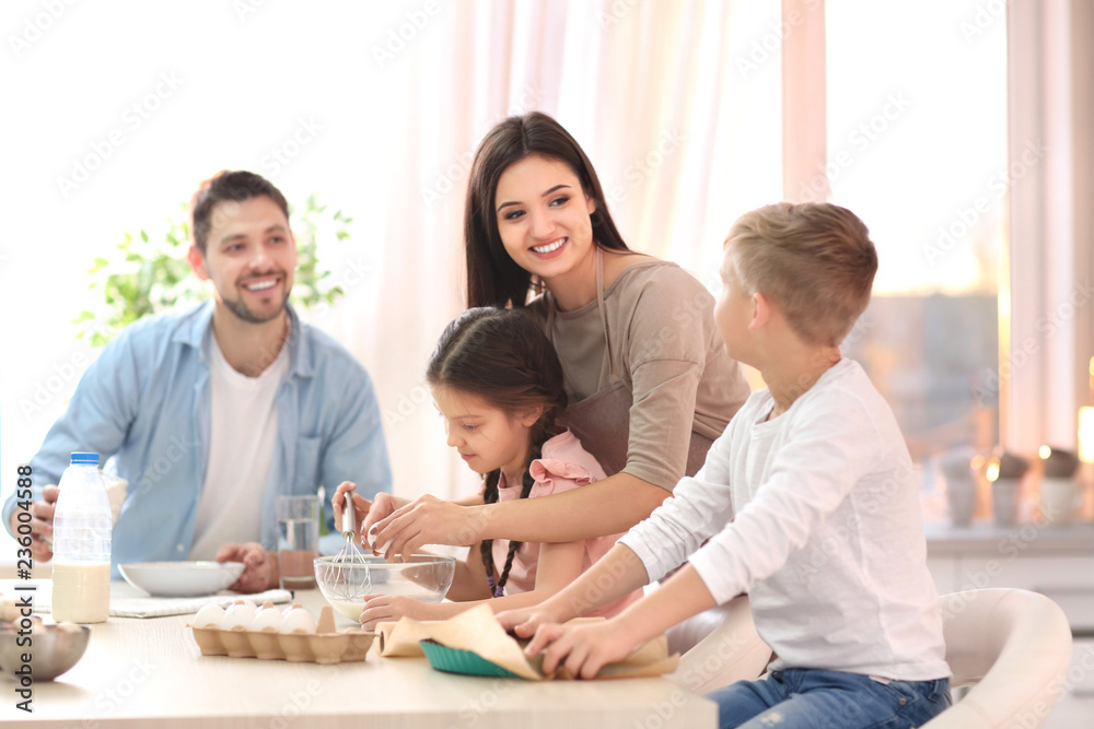 Happy family cooking pastries together in kitchen Happy family cooking pastries together in kitchen
