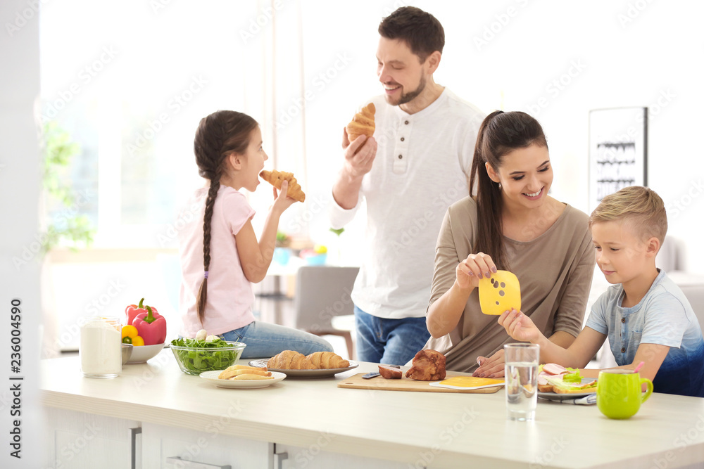 Happy family having breakfast together in kitchen Happy family having breakfast together in kitchen
