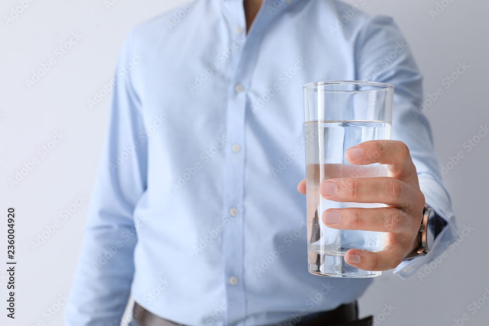 Man holding glass of pure water on white background, closeup Man holding glass of pure water on white background, closeup