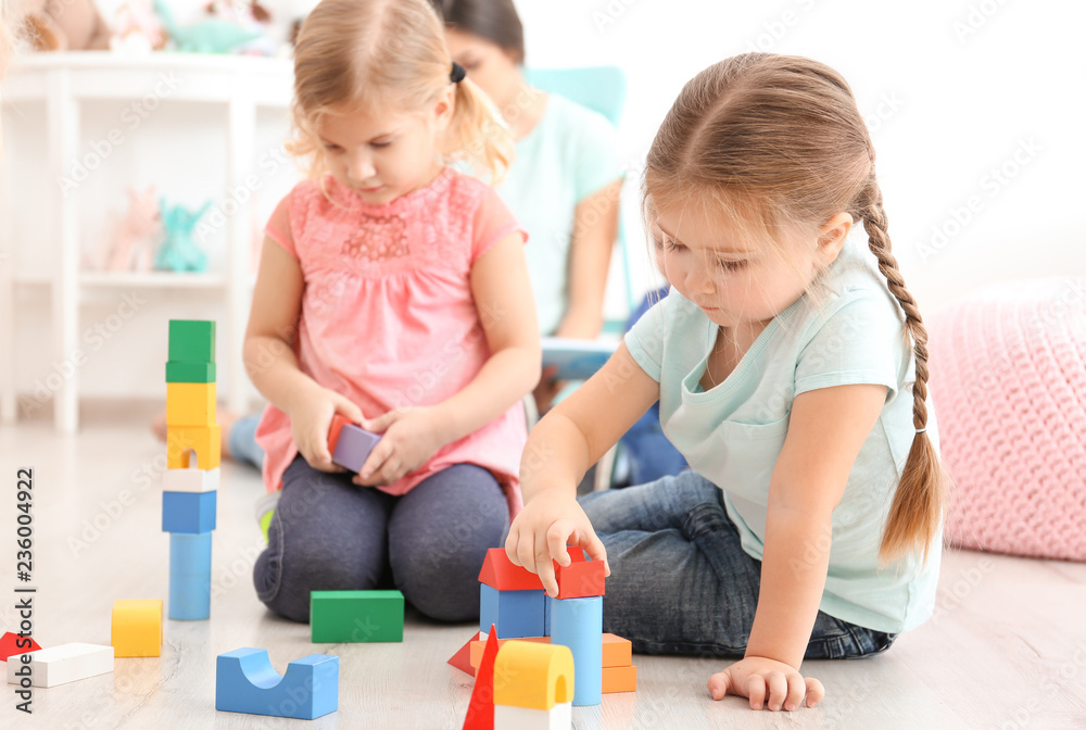 Cute little children playing with blocks in kindergarten Cute little children playing with blocks in kindergarten