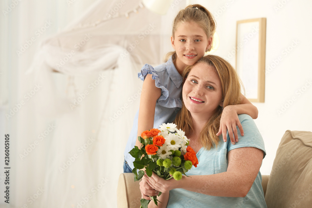 Portrait of happy mother and daughter with bouquet of flowers at home Portrait of happy mother and daughter with bouquet of flowers at home