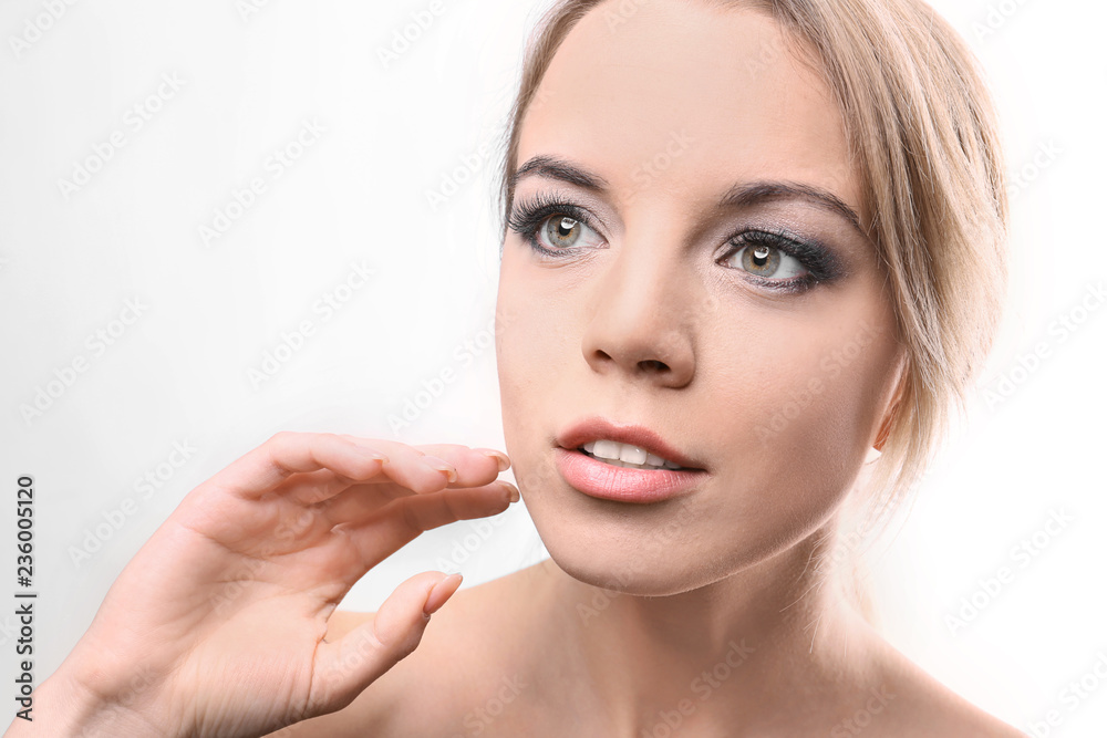 Fototapeta premium Portrait of beautiful young woman with eyelash extensions on light background