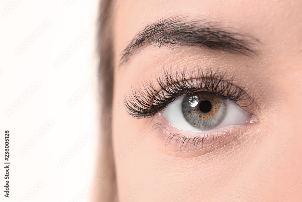 Obraz premium Piękna młoda kobieta z przedłużaniem rzęs na białym tle, zbliżenie