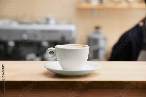 Cup of fresh aromatic coffee on table against blurred background