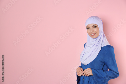 Portrait of young Muslim woman in hijab against color background. Space for text