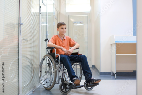 Little boy sitting in wheelchair indoors
