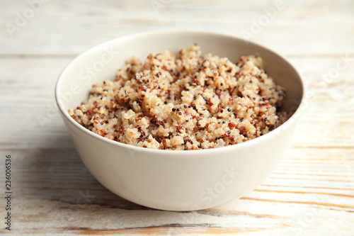 Cooked delicious quinoa in bowl on  wooden table