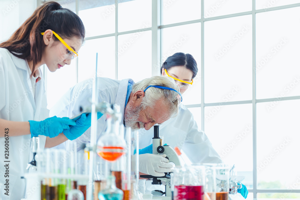 Science teacher and students team working with chemicals in lab
