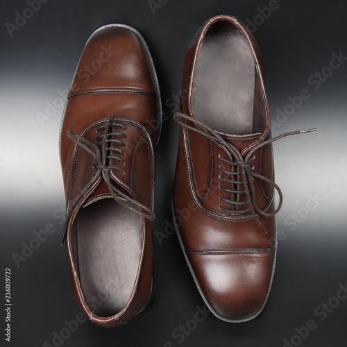 Classic men's brown Oxford shoes on dark background