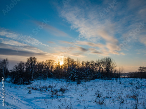 winter sunset over the field and forest with clouds, Novosibirsk, Russia