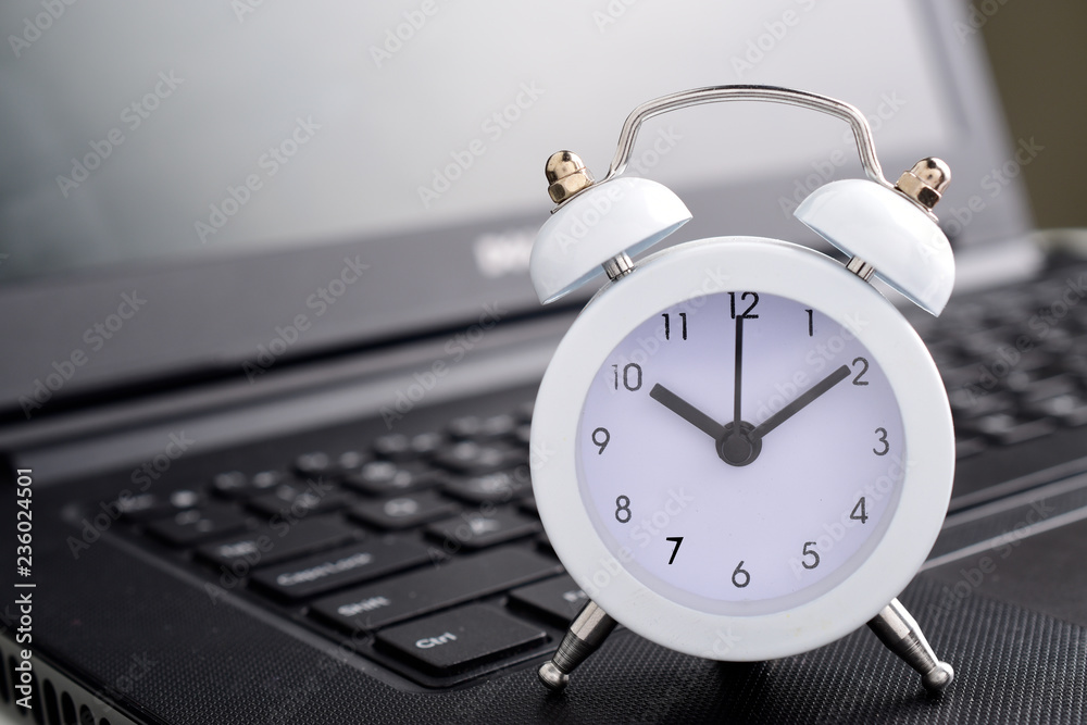 clock on laptop computer concept for time management concept.