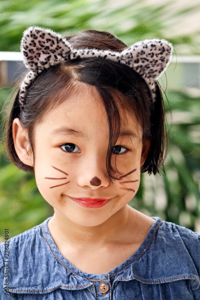 cute young girl with cat face paint Stock-Foto | Adobe Stock