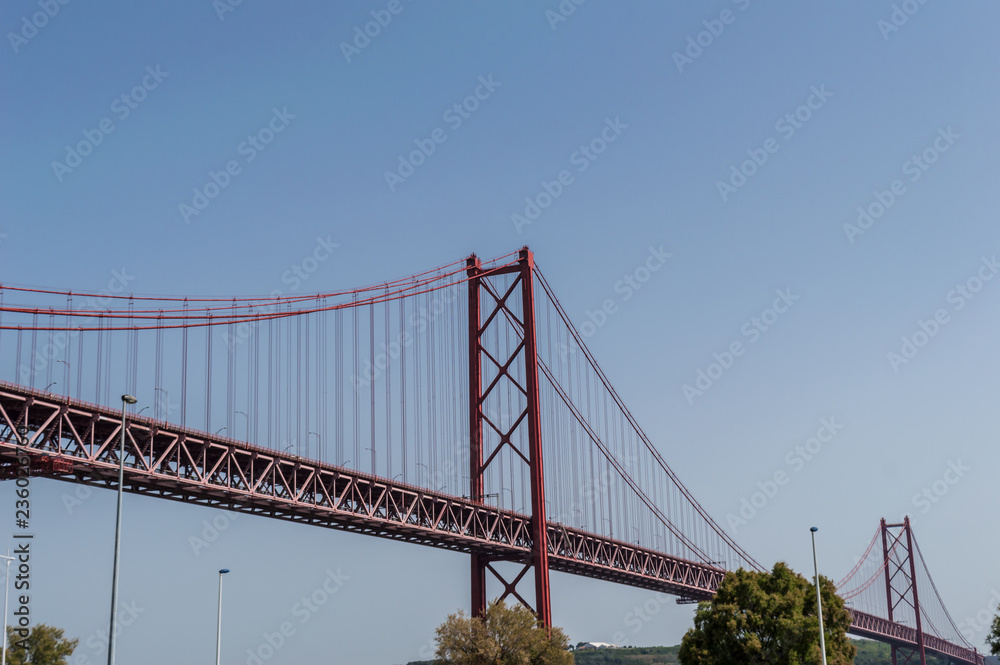 Closeup of the bridge '25 of April' against blue sky on a clear day Closeup of the bridge '25 of April' against blue sky on a clear day