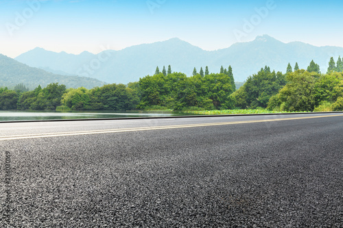 Empty asphalt road and green mountains © ABCDstock