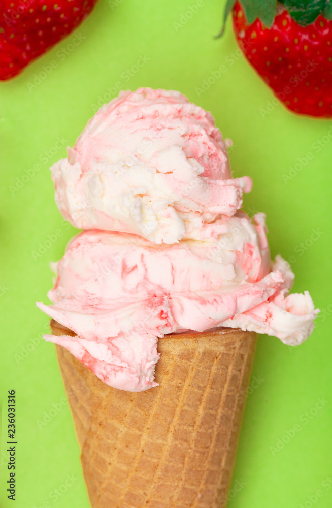 Double Scoop of Strawberry Ice Cream in a Waffle Cone on a Green Background