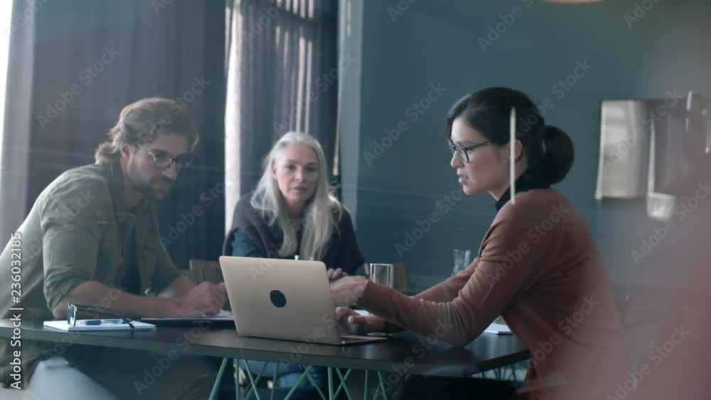 Confident asian business woman discussing with colleague a project pointing at laptop. Female business professional showing and sharing her ideas for the new project on laptop with senior team members Confident asian business woman discussing with colleague a project pointing at laptop. Female business professional showing and sharing her ideas for the new project on laptop with senior team members