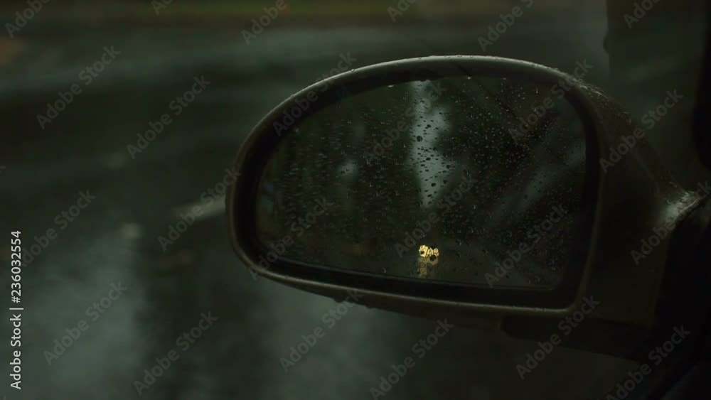 Raindrop outside the car in raining day. Raindrops on car window and rear view mirror. wing mirror. Morning dew drops on a car side mirror passenger side for raint seaon concept Raindrop outside the car in raining day. Raindrops on car window and rear view mirror. wing mirror. Morning dew drops on a car side mirror passenger side for raint seaon concept