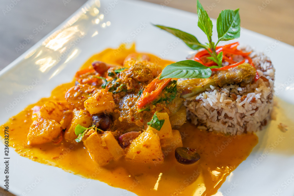 duck confit with red curry served with brown rice on plate duck confit with red curry served with brown rice on plate