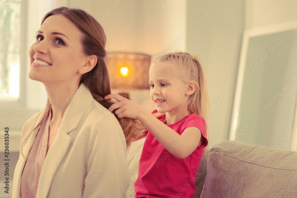 Pleasant nice girl doing a hairstyle for her mom Pleasant nice girl doing a hairstyle for her mom
