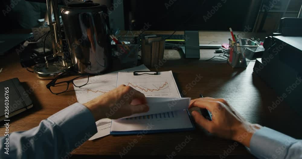 Person view while turning the light on, check some documents and singn on of them.Concept: Business, office, finance