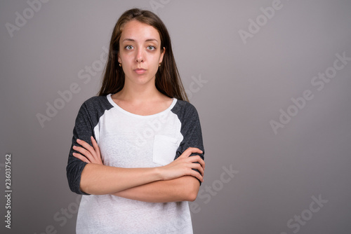 Portrait of young beautiful woman against gray background