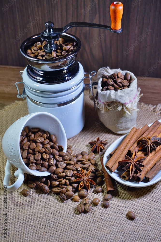 Aromatic coffee beans in a mug and mill and spices Aromatic coffee beans in a mug and mill and spices