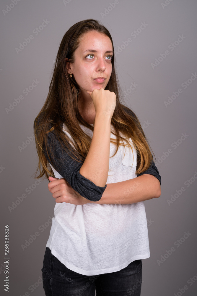 Portrait of young beautiful woman against gray background Portrait of young beautiful woman against gray background
