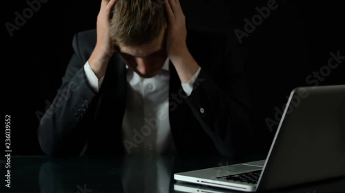 Bankrupt sitting in front of laptop, money disappearing from table, business