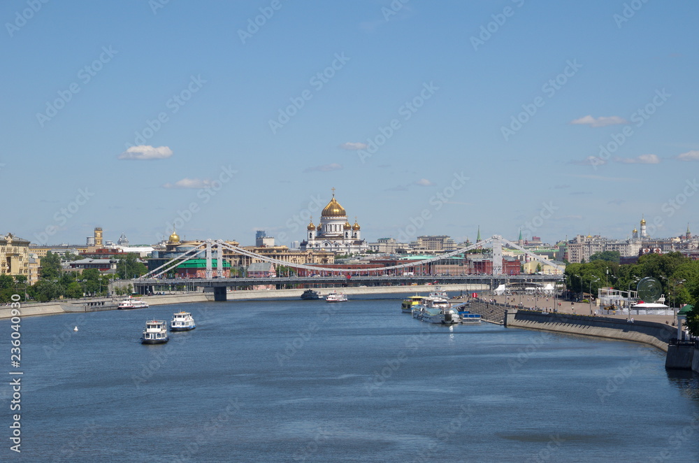 Summer view of the Crimean bridge, the Cathedral of Christ the Saviour and the Moscow-river with pleasure boats. Moscow, Russia