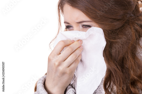Fotografia Sick freezing woman sneezing in tissue