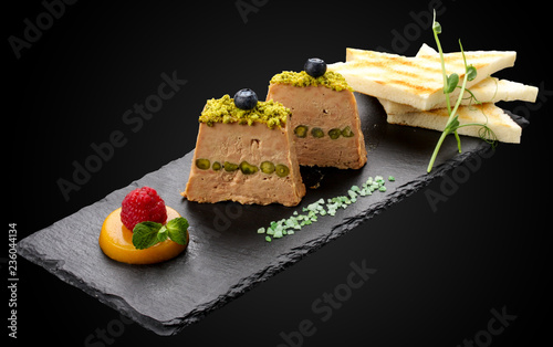 Terrine of Foie Gras with pistachio nuts on a dark background