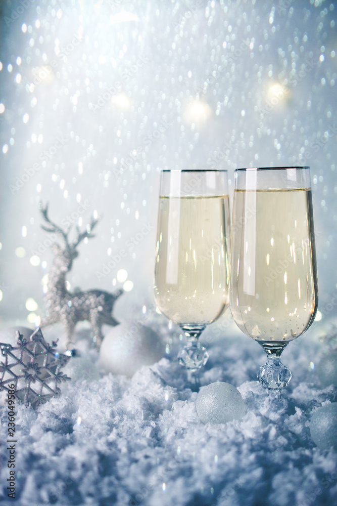 New Year and Christmas Celebration .Two Champagne Glasses and Holiday decoration. Beautiful shiny place setting for Christmas. Sparkler background, winter season. New Year and Christmas Celebration .Two Champagne Glasses and Holiday decoration. Beautiful shiny place setting for Christmas. Sparkler background, winter season.