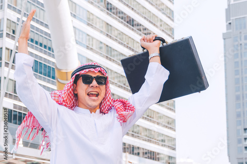 Arab businessman standing by raising both hands up in city