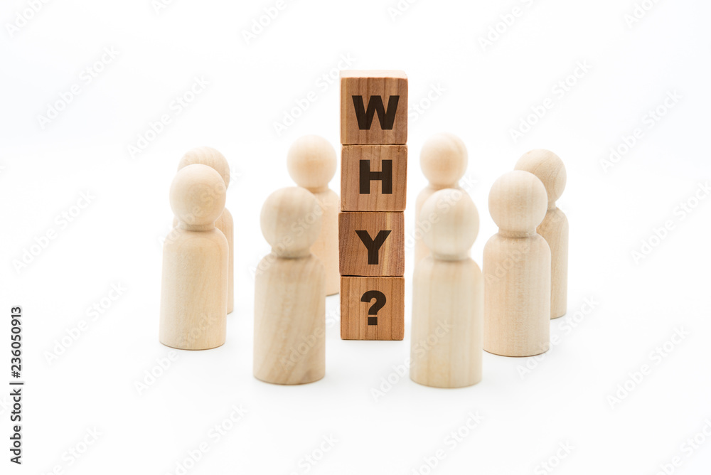 Wooden figures as business team in circle around word WHY