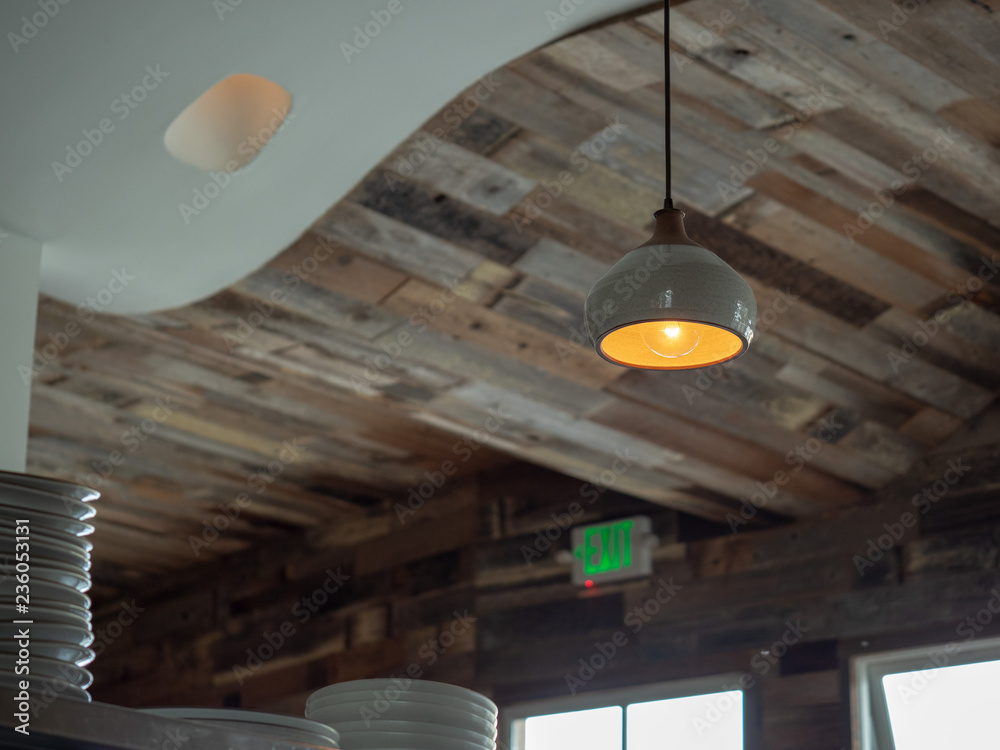 Wooden roof of trendy restaurant with hanging lights and stack of ceramic plates Wooden roof of trendy restaurant with hanging lights and stack of ceramic plates