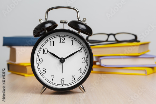 Back to school background with books and alarm clock