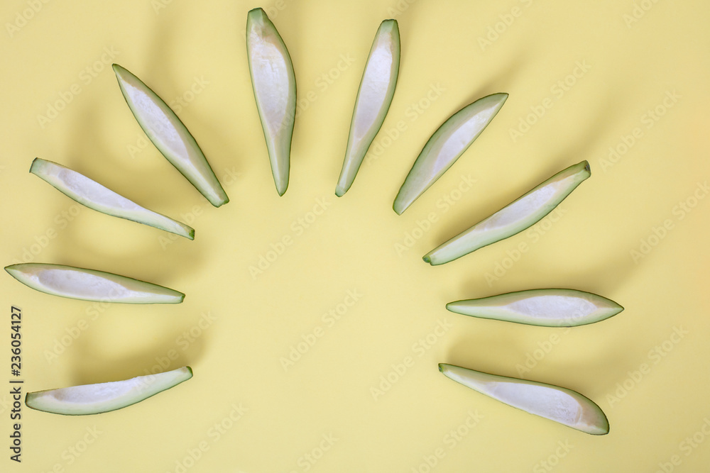 Fototapeta premium Avocado slices isolated on yellow background