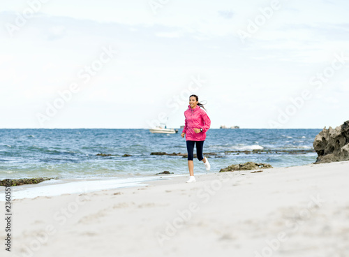 Young Woman Jogging On The Beach