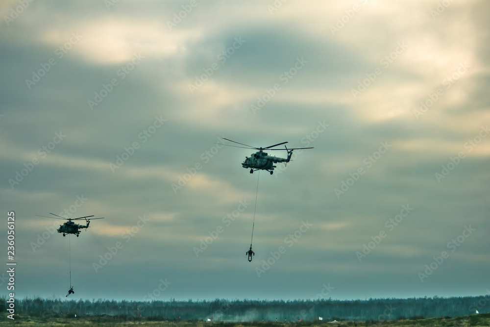 military army helicopter transporting an artillery piece. military army helicopter transporting an artillery piece.