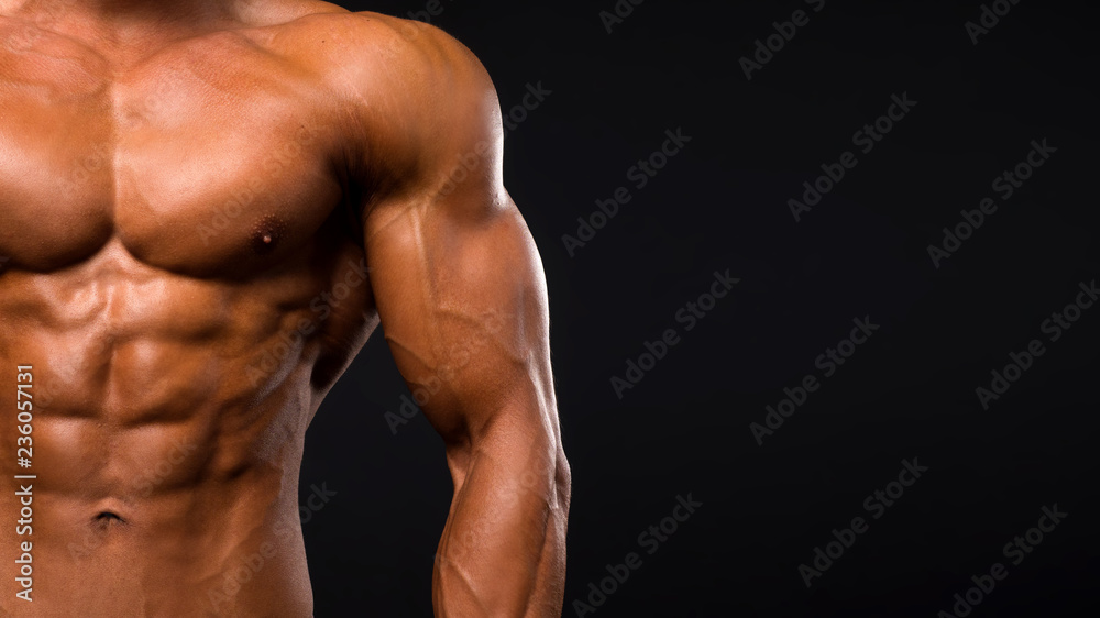 Male shirtless torso on dark background. Perfect abs Male shirtless torso on dark background. Perfect abs