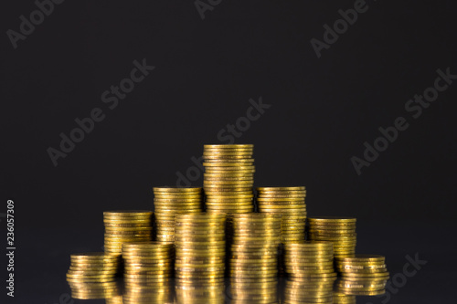 Increasing columns of coins, step of stacks coin on dark background with copy space for business and financial concept.