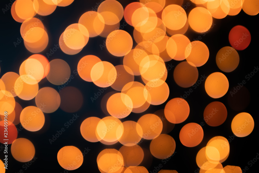 Yellow Christmas Tree Bokeh on black background of defocused glittering lights, Christmas background pattern concept
