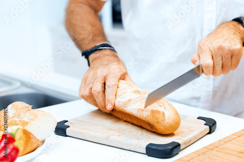 Male hands cutting bread