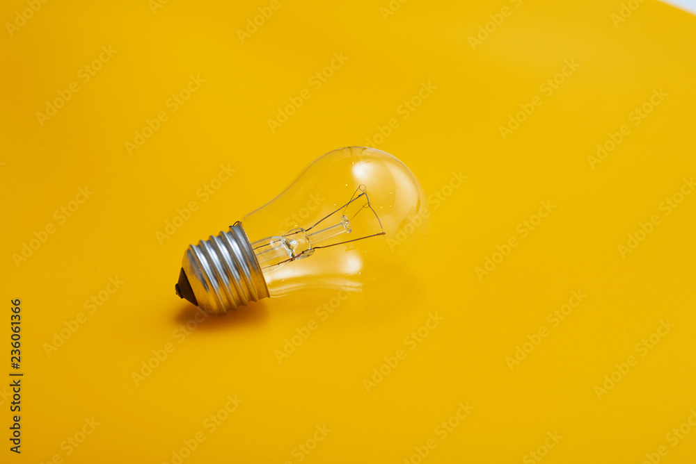 close up view of white light bulb isolated on yellow close up view of white light bulb isolated on yellow