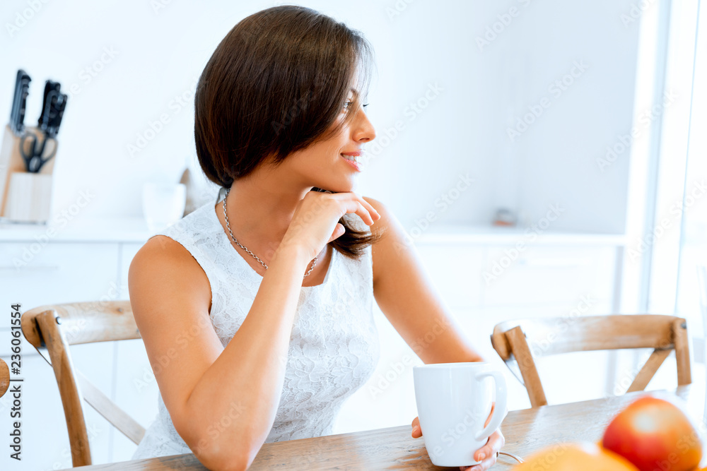 Happy young woman with cup of tea or coffee at home Happy young woman with cup of tea or coffee at home