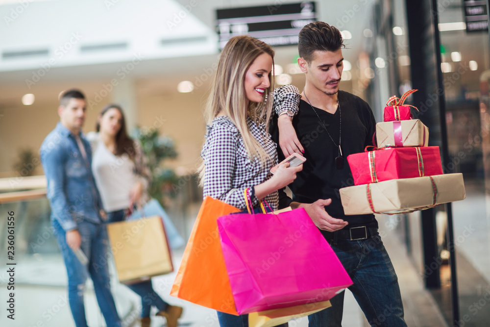 Young couple doing Christmas shopping in the shopping mall Young couple doing Christmas shopping in the shopping mall