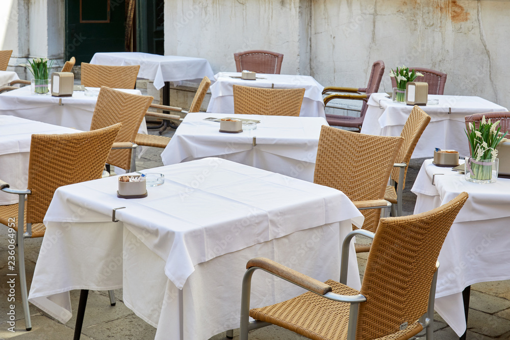 Empty sidewalk tables and chairs in a sunny morning